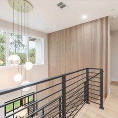 an empty room with wooden slats on the wall and metal handrails hanging from the ceiling