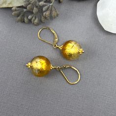 "✦Venetian Murano glass is known for its unique qualities and beautiful colors, which are created using different techniques and materials. The gold foil used in these earrings is a common technique used in Murano glass to create a rich, luxurious appearance.  Overall, these earrings would make a beautiful and thoughtful gift for anyone who appreciates the artistry and history of Murano glass. They make the perfect gift for mom! ✦Beads are authentic Italian Venetian Murano glass with a round shape, 12mm in diameter.  The beads are accented with gold vermeil daisy spacers to create a stunning look.   ✦Ear wires: 14k gold-filled secure leverback or French hook ear wires.  French hook ear wires come with rubber grommets for added security. Please select ear wire style at check out. ✦The lengt Murano Glass Jewelry, Leverback Earrings, Authentic Italian, Perfect Gift For Mom, Bead Earrings, Glass Jewelry, Jewelry Handmade, Ear Wire, Murano Glass