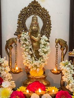 the statue is surrounded by flowers and candles