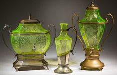 three green glass vases sitting next to each other