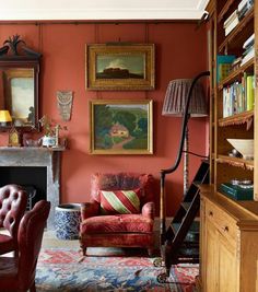 a living room filled with furniture and paintings on the wall