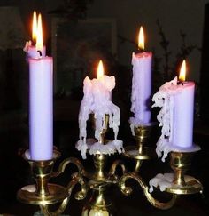 four lit candles are sitting on a table