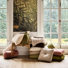 a room filled with lots of different types of pillows and blankets on top of each other