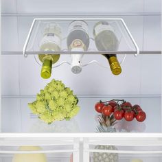 an open refrigerator filled with lots of different types of vegetables and wine bottles in it