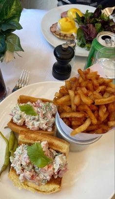 there is a sandwich and french fries on the plate next to each other at this table