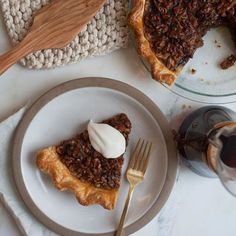 a slice of pecan pie on a plate with a fork and glass of wine