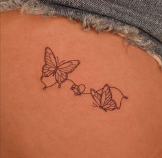 two butterflies on the back of a woman's left side ribcage tattoo