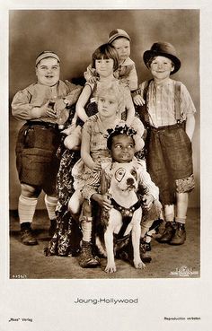 an old black and white photo of children posing for a picture with a dog on their lap