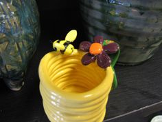 a yellow vase sitting on top of a wooden table