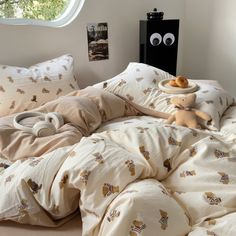 an unmade bed with two stuffed animals on the pillows and one has donuts in front of it