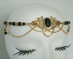 "This beautiful circlet has black glass beads, gold plated accent beads, gold plated chain, brass side accent pieces, brass pendant and black cats eye stone setting with rhinestones. 20\" long can be adjusted to 24\". Lobster clasp." Elegant Round Metal Body Jewelry, Elegant Handmade Adjustable Body Jewelry, Gold Gothic Party Jewelry, Gold Gothic Jewelry For Parties, Elegant Handmade Gold Body Jewelry, Gothic Gold Jewelry For Formal Occasions, Gothic Gold Party Jewelry, Bohemian Gold Jewelry With Historical Design, Gold Headband Jewelry Gift