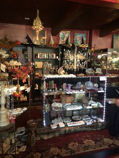 a store filled with lots of items on display in front of a man sitting at a table