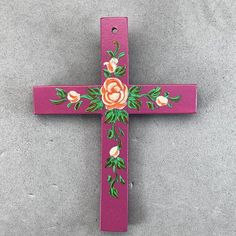 a wooden cross with flowers painted on it