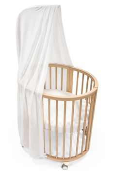 a baby crib with a white sheet draped over it