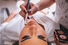 a woman getting her make - up done at a beauty salon