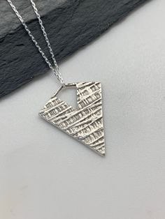 This modern silver triangle necklace has been entirely handmade using .999 fine silver. It has been cut from fine silver precious metal clay, textured, fired and oxidized. The pendant hangs from a sterling silver diamond cut cable chain. This lovely reversible pendant has a basket weave pattern on one side and a unique modern edgy striped deco pattern on the reverse side. Pendant size: approximately 1 x 3/4 inches Chain length: adjustable at 16 and 18 inches can also be customized to whatever le Metal Clay Pendant, Precious Metal Clay Jewelry, Necklace Art Deco, Moon Necklace Silver, Basket Weave Pattern, Handmade Silver Jewellery, Silver Clay, Necklace Art, Silver Bar Necklace