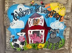 a welcome sign for the farm with cows and pigs on it's front door