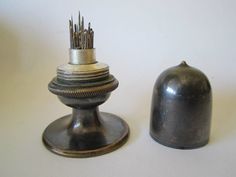 an antique silver salt and pepper shaker on a white surface with the lid off