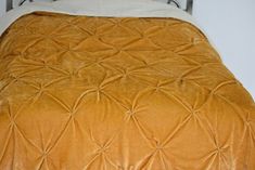 a bed with an orange comforter and white sheets