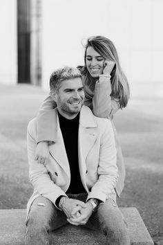 a man sitting on top of a woman's back while she is holding her