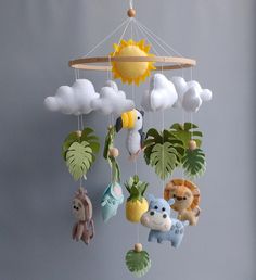 a mobile with stuffed animals hanging from it's sides and clouds in the background