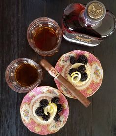 two plates with desserts on them next to bottles of liquor