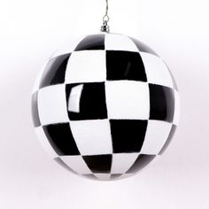 a black and white checkered ornament hanging from a metal hook on a chain