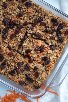 a glass dish filled with granola and raisins on top of a table