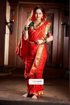 a woman in a red sari posing for the camera