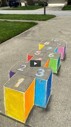 the sidewalk has been painted with chalk and numbers on it, as if they were cubes