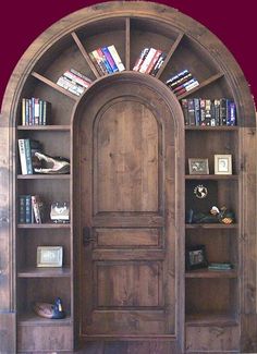 an arched wooden door with books on shelves