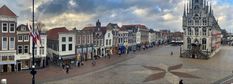 an aerial view of a town square with people walking around and buildings in the background