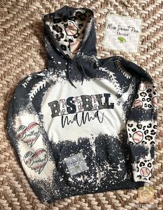 How cute is this mama hoodie!! Personalized with your kids names, can also make this for grandmas, aunts whoever!! Just message me Remember no 2 hoodies will be the exact same bleach pattern, and may have light spotting  All hoodies are depending on weather and may take a bit to make. Baseball Mama Outfit, Mama Hoodie Ideas, Baseball Mom Hoodie, Casual Customizable Hoodie For Sports Events, Casual Personalized Hooded Hoodie, Casual Hoodie With Name Print, Casual Fall Hoodie With Name Print, Game Day Cotton Hoodie, Pre-shrunk, Game Day Cotton Hoodie Pre-shrunk