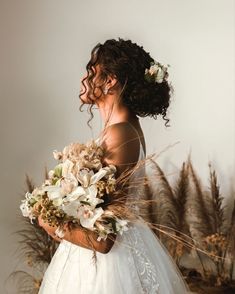 a woman in a wedding dress holding flowers