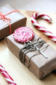 some candy canes wrapped in brown paper and tied with twine on a table