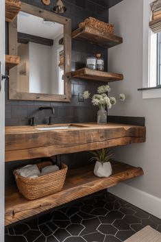 a bathroom with black tile and wooden shelves on the wall, along with a sink