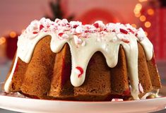 a bundt cake with white icing and sprinkles on top sitting on a plate