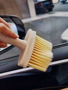 a person holding a brush in their hand and cleaning the inside of a car door