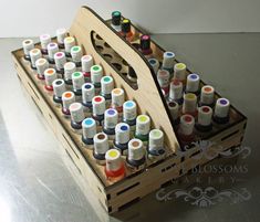 a wooden box filled with lots of different colored bottles