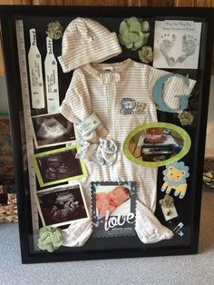 a baby's photo is displayed in a shadow box with pictures and other items