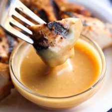 a fork lifting up some food out of a small glass bowl on a white plate