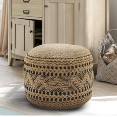 a basket sitting on top of a wooden floor next to a dresser and cabinet in a room