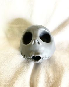 a skull mask is laying on a white sheet