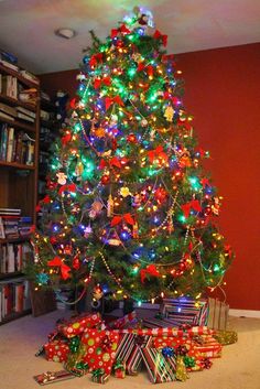 a brightly lit christmas tree with presents under it