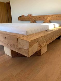 a wooden bed frame sitting on top of a hard wood floor