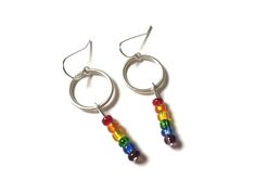 two pairs of earrings with rainbow beads hanging from the ends of hoops on a white background