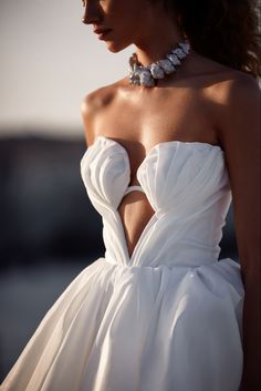 a woman wearing a white dress and necklace