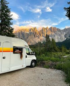 a camper van parked on the side of a road with mountains in the background