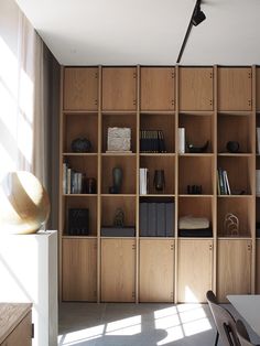 a wooden bookcase with many books on it in a room filled with chairs and tables