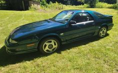 a green sports car parked in the grass